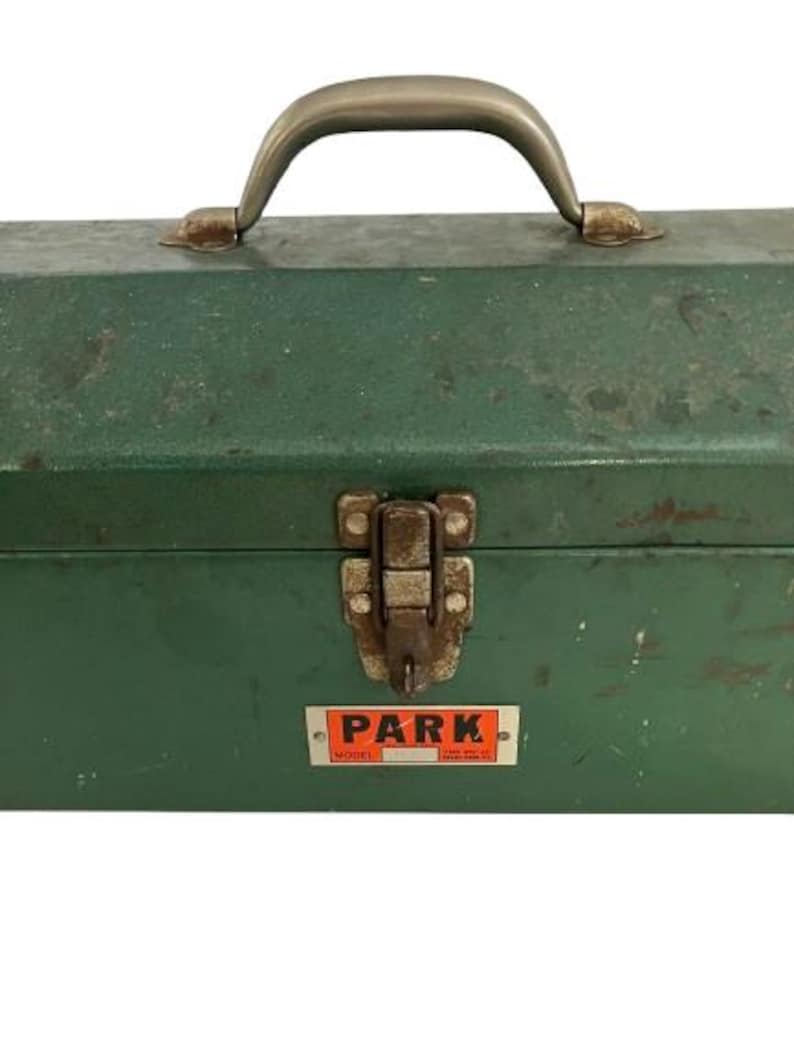 May include: Green metal toolbox with a silver handle and a latch. The toolbox has a sticker on the front that says "PARK MODEL".