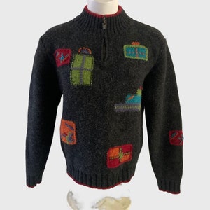 May include: A gray knitted sweater with a half-zip closure and colorful embroidered gift designs.