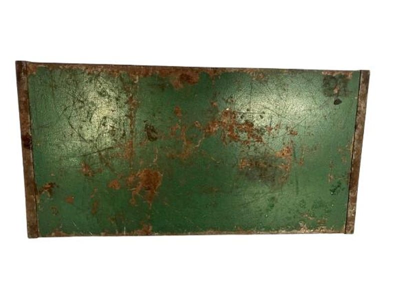 May include: A vintage green metal box with rust and scratches. The box has a rectangular shape and is made of metal. The box is old and has been used for a long time.