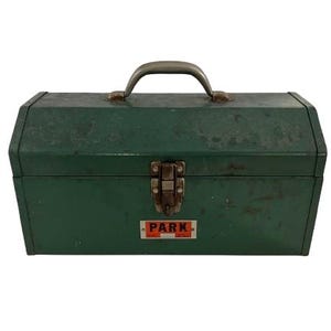 May include: Green metal toolbox with a silver handle and a latch. The toolbox has a label that says "PARK" in red letters.