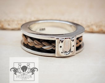 May include: A silver ring featuring a braided horsehair band and a silver horseshoe charm. The ring is a unique and personalised piece of jewellery.