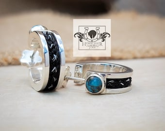 May include: A pair of silver hoop earrings with black horsehair braid accents. One earring features a turquoise stone.