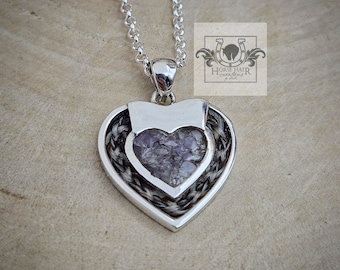 Könnte beinhalten: Ein silberner herzförmiger Anhänger mit einem Hufeisen-Design und einem violetten Amethyst-Stein im Inneren. Der Anhänger ist an einer silbernen Kette.