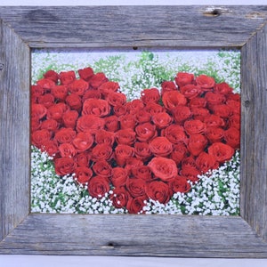 May include: A rustic wooden frame with a heart-shaped arrangement of red roses surrounded by white baby's breath.