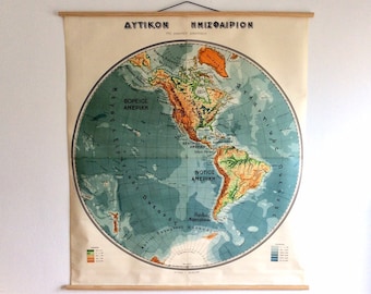 May include: A vintage educational map of the Western Hemisphere, printed on a light beige background. The map is titled "ΔΥΤΙΚΟΝ ΗΜΙΣΦΑΙΡΙΟΝ" in Greek, which translates to "Western Hemisphere". The map features a blue ocean with a green and brown landmass representing North and South America. The map is framed with a wooden frame.