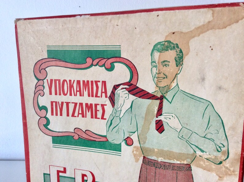 May include: Vintage advertisement featuring a man adjusting a red and black striped tie. The illustration is in a retro style, with a green and pink decorative border and Greek text. The man is wearing a light green shirt and red striped pants.