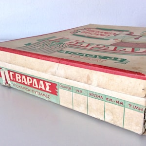 May include: Vintage cardboard box with red and green text and graphics. The box has a worn, aged appearance, with visible creases and wear on the edges. The box is labeled "&Gamma;. &Beta;&Alpha;&Rho;&Delta;&Alpha;&Sigma;" and "&Upsilon;&Pi;&Omicron;&Kappa;&Alpha;&Mu;&Iota;&Sigma;&Alpha;-&Pi;&Upsilon;&Tau;&Zeta;&Alpha;&Mu;&Epsilon;&Sigma;".