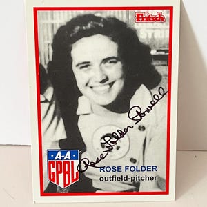 May include: A baseball card featuring a black and white image of Rose Folder, an outfielder-pitcher. The card has a red border and includes the text "Rose Folder" and "outfield-pitcher". The A-A GPBL logo is visible.
