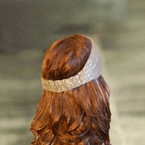 Puede incluir: Una mujer con el pelo largo, ondulado y casta&ntilde;o rojizo lleva una diadema marr&oacute;n claro con un dise&ntilde;o texturizado.