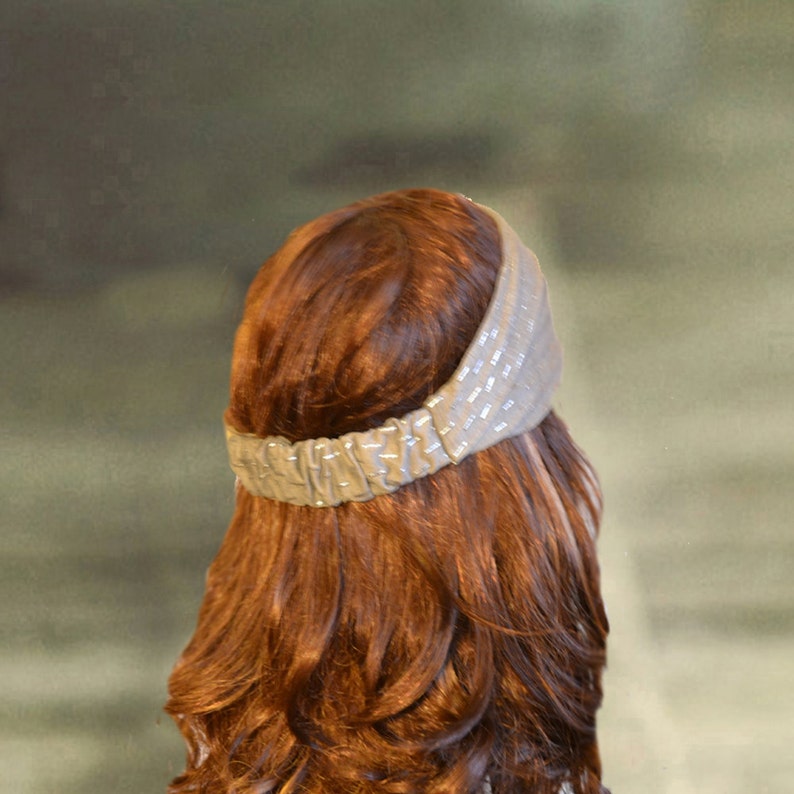 Puede incluir: Una mujer con el pelo largo, ondulado y casta&ntilde;o rojizo lleva una diadema marr&oacute;n claro con un dise&ntilde;o texturizado.
