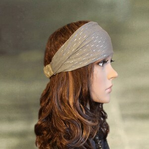 Puede incluir: Una diadema gris con detalles de purpurina plateada. La diadema se lleva en un maniqu&iacute; con el pelo largo y casta&ntilde;o.
