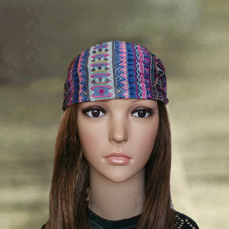 Pode incluir: Uma faixa de cabe&ccedil;a com padr&atilde;o geom&eacute;trico azul, rosa e branco. A faixa de cabe&ccedil;a est&aacute; sendo usada em um manequim com cabelo longo e castanho.