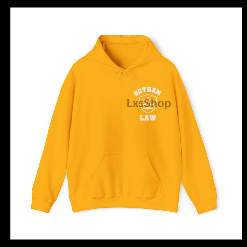 Op de afbeelding: Een gele hoodie met een witte afbeelding op de voorkant met de tekst "Gotham Law" met een schild en kroonontwerp.