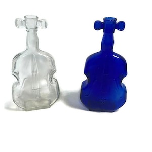 May include: Two glass violin-shaped bottles, one clear and one cobalt blue.