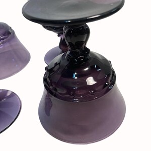 a close-up view of a set of purple glassware, including wine glasses and a bowl.