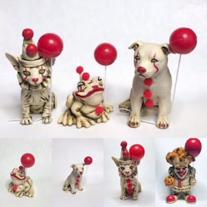Puede incluir: Un conjunto de cinco figuritas de cerámica, cada una representando un animal diferente vestido de payaso. Los animales incluyen un gato, un perro, una rana y dos payasos. Cada figurita sostiene un globo rojo.