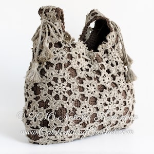 Può includere: Una borsa a mano all'uncinetto con base marrone e dettagli in crochet beige. La borsa ha una parte superiore grande e aperta e due manici lunghi. La borsa è decorata con frange sui manici.