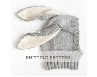 May include: Knitting pattern for a gray bunny hat with white ears. The hat is made with a simple stitch pattern and has a ribbed brim.