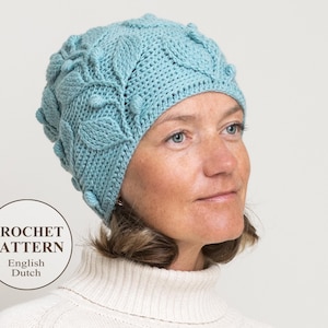 May include: A light blue crocheted hat with a leaf pattern. The hat has a textured surface and is made with a soft yarn.