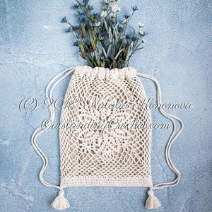 Crochet bag pattern: Lotus lace drawstring backpack with beautiful lace motifs on moth sides and fabric lining, decorated with tassels.