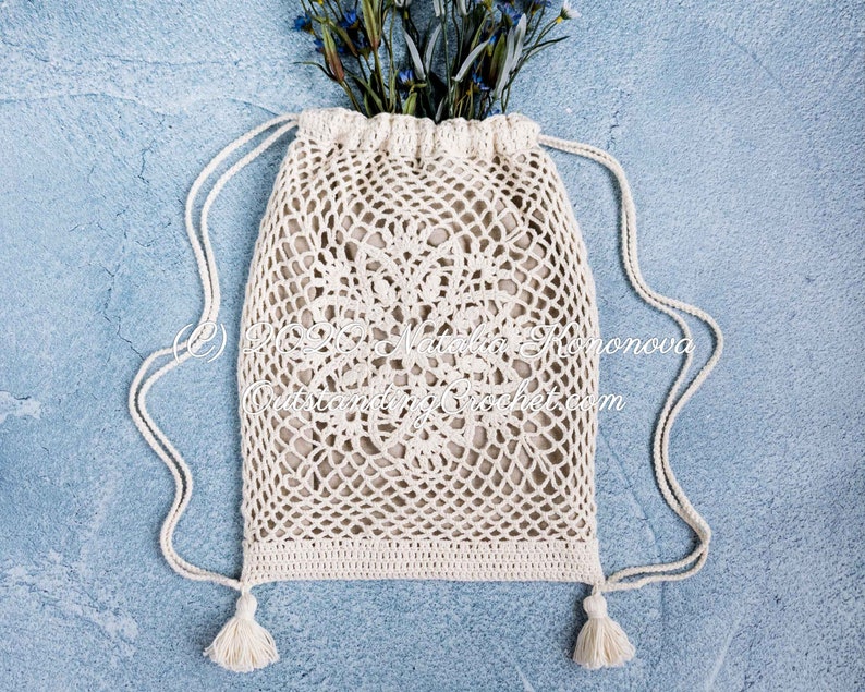 Crochet bag pattern: Lotus lace drawstring backpack with beautiful lace motifs on moth sides and fabric lining, decorated with tassels.