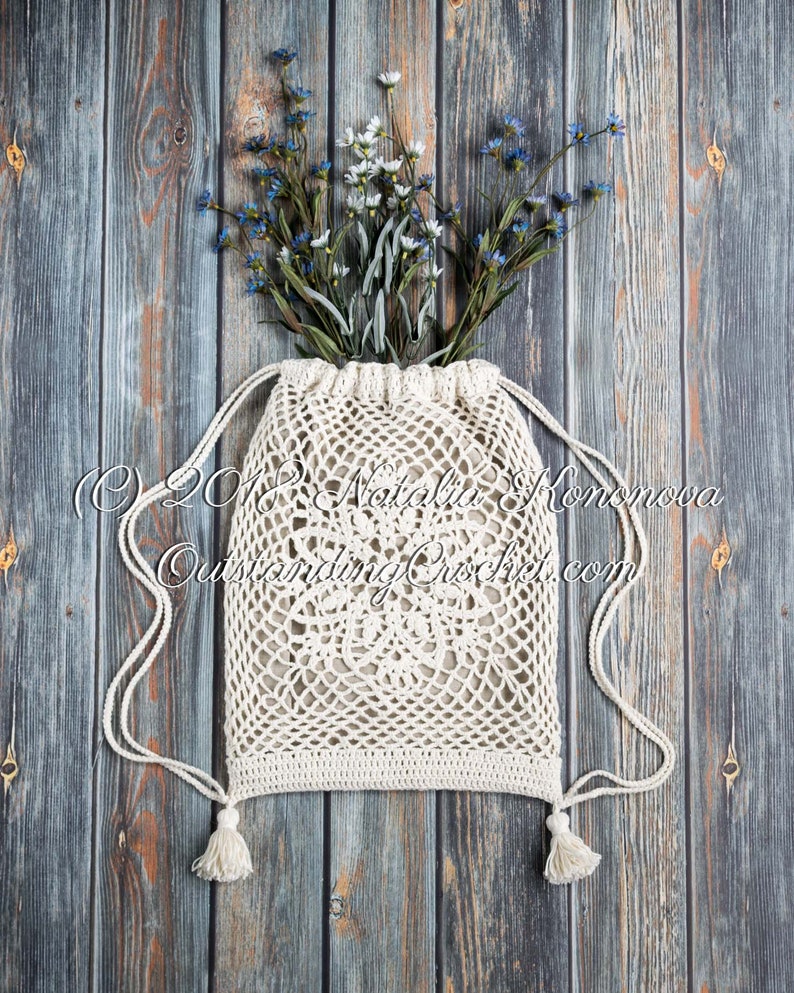 Crochet bag pattern: Lotus lace drawstring backpack with beautiful lace motifs on moth sides and fabric lining, decorated with tassels.