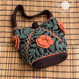 Peut inclure: Un sac à main en crochet marron foncé avec une superposition à motif de feuilles vert foncé, orné de trois fleurs en crochet orange et d'une anse unique. Le sac comprend une fermeture à bouton centrale et le texte Outstanding Crochet.com.