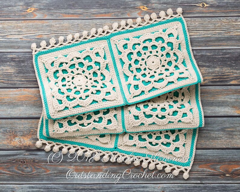 Puede incluir: Una pila de cuatro cuadrados tejidos a crochet con un borde turquesa y detalles de crochet blanco. Los cuadrados tienen un borde de flecos con pompones blancos. Los cuadrados est&aacute;n sobre una superficie de madera. (C) 2018 Natalia Honcharova OutstandingCrochet.com
