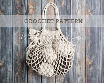 Puede incluir: Una bolsa de mercado de crochet con un patrón de color blanco y marrón. La bolsa tiene un asa y dos borlas. La bolsa está sobre un fondo de madera. CROCHET PATTERN está escrito en la parte superior de la imagen.