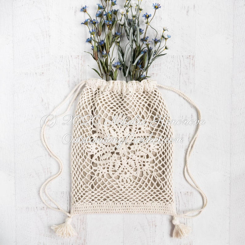 Crochet bag pattern: Lotus lace drawstring backpack with beautiful lace motifs on moth sides and fabric lining, decorated with tassels.