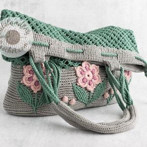 Crochet bag pattern: a shoulder bag with a combination of embossed crochet bottom with 3D flowers and leaves and a net top. Beautiful original multi-corded handles and a drawstring that goes through the top.