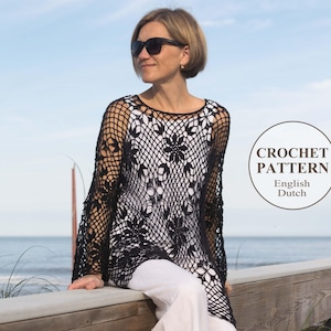 May include: A black crochet poncho with a floral design. The poncho is worn by a person standing on a wooden railing overlooking the ocean.