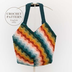 Puede incluir: Un bolso tote de ganchillo hecho a mano y colorido con un patrón de chevrón. El bolso presenta una variedad de colores que incluyen verde azulado, naranja, amarillo y rosa. Tiene correas de color verde azulado y el texto "CROCHET PATTERN English only" en un círculo.