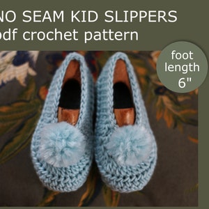 May include: A pair of light blue crocheted slippers with a fluffy pom-pom on each toe. The slippers are designed for a foot length of 6 inches. The text "NO SEAM KID SLIPPERS pdf crochet pattern" is at the top of the image.