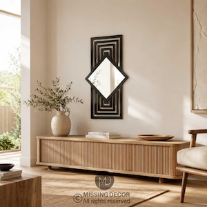 Peut inclure: Un miroir mural rectangulaire doté d'un cadre noir avec un motif de carrés concentriques et une surface réfléchissante centrale en forme de losange. Le design se compose de lignes noires imbriquées formant un cadre géométrique.