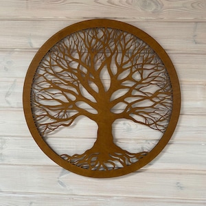 Op de afbeelding: Ronde houten wanddecoratie met een gedetailleerd boomontwerp. De boom, met zijn ingewikkelde takken en wortels, is ingesloten in een cirkelvormig frame. Het hout heeft een warme, bruine tint, wat een natuurlijk en decoratief element creëert.