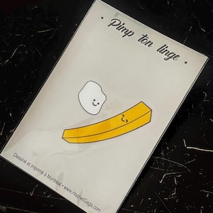 May include: A rectangular white card featuring the black text Pimp ton linge at the top. Below, a cartoon illustration shows a small white blob with a smiling face hovering over a yellow French fry with a small, curved black line on its surface.