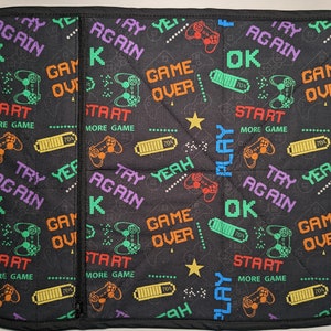 May include: Black and green gaming themed fabric with a repeating pattern of game controllers, batteries, and text that says "Try Again", "Game Over", "OK", "Start", "More Game", "Yeah", and "Play".