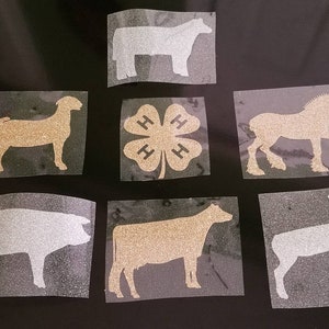 May include: Nine glitter iron-on decals featuring various farm animals, including a pig, cow, horse, sheep, goat, and a 4-H clover.
