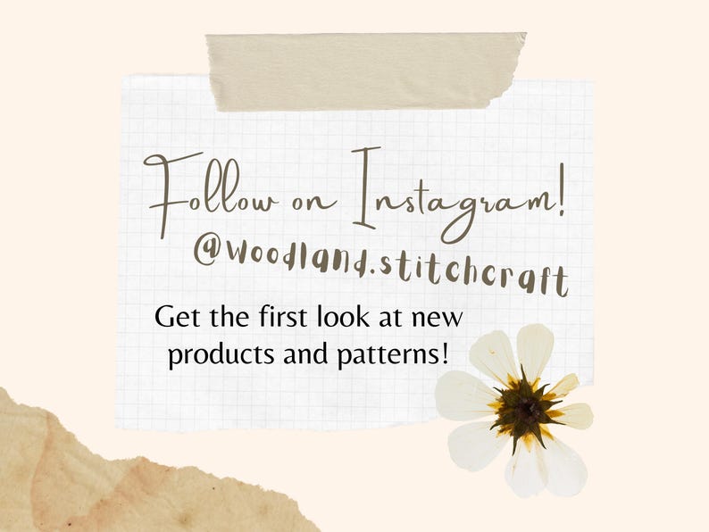 May include: A white piece of paper with a grid pattern, taped to a beige background. The paper has handwritten text that says "Follow on Instagram! @woodland.stitchcraft Get the first look at new products and patterns!" A white flower with a brown center is in the bottom right corner of the paper.