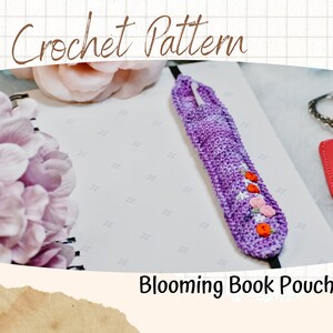 Könnte beinhalten: Eine lila gehäkelte Buchhülle mit gestickten Blumen in Orange und Rosa. Die Hülle liegt auf einem weißen Notizbuch mit dem Text "Blooming Book Pouch".