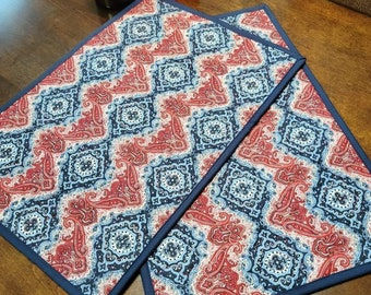 Peut inclure: Deux sets de table à motifs rouge, blanc et bleu avec une bordure bleu marine. Les sets de table ont un motif paisley.