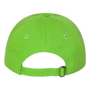 Puede incluir: Una gorra de b&eacute;isbol verde brillante con una correa ajustable marr&oacute;n.