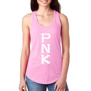 May include: Pink racerback tank top with the word "PNK" printed vertically in white block letters. The tank top is a solid light pink color and has a rounded neckline.