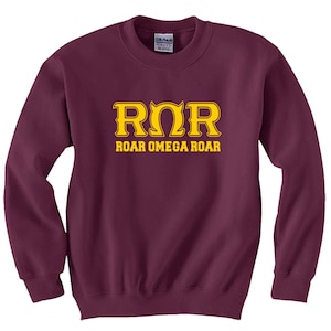 May include: Burgundy sweatshirt with a gold Greek letter Omega and the text "ROR ROAR OMEGA ROAR" printed on the front.