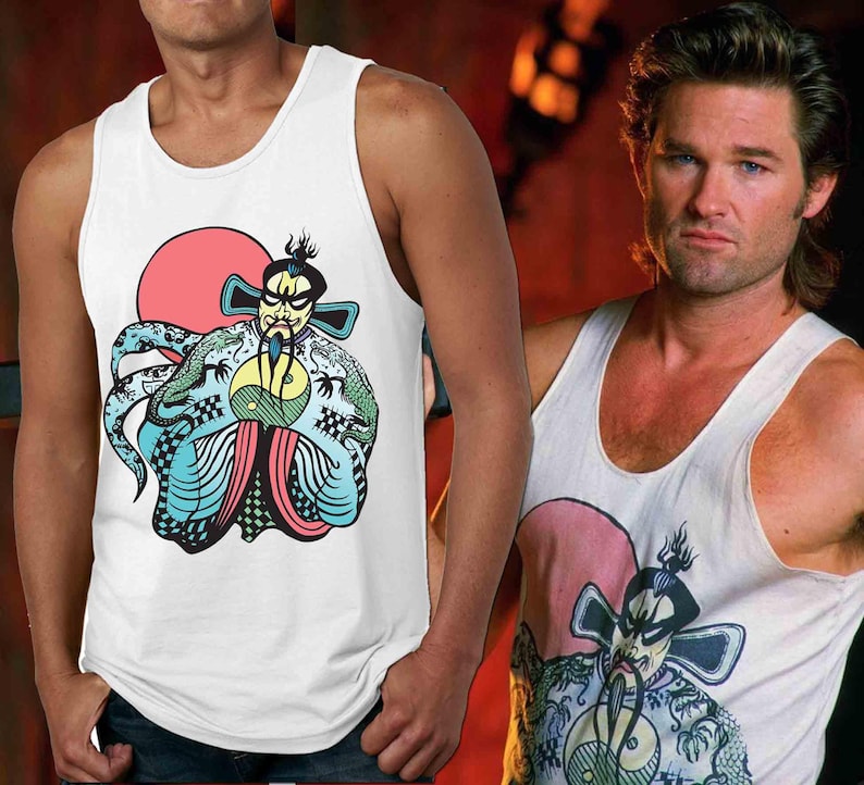 May include: White tank top with a colorful graphic print of a cartoon character with a red sun behind it. The character is wearing a green and blue robe and holding a yin yang symbol.