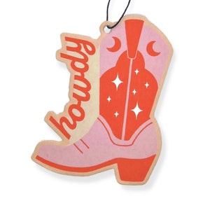 May include: A pink cowboy boot with a red top and white stars. The boot has the word "Howdy" written on the side in a yellow font.