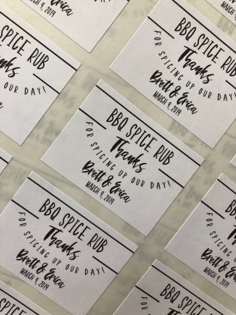 May include: White favor tags with black text that reads "BBQ Spice Rub Thanks for Spicing Up Our Day! Brett & Erica March 9, 2019".