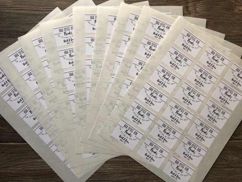 May include: A stack of white sheets of paper with rectangular labels printed with the text "BBQ Spice Rub Thanks for trying our Built & Brew BBQ Spice Rub".