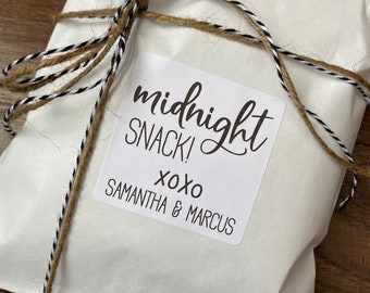 May include: A white paper bag tied with twine and a black and white striped ribbon. A white sticker with black text reads "midnight snack! xoxo Samantha & Marcus".